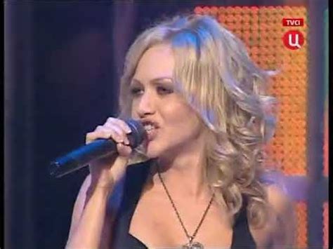 a woman with blonde hair singing into a microphone