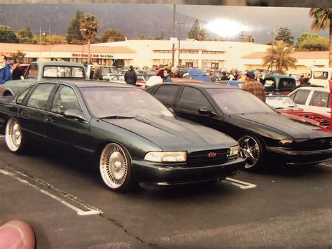 Two Black Cars Parked in a Parking Lot