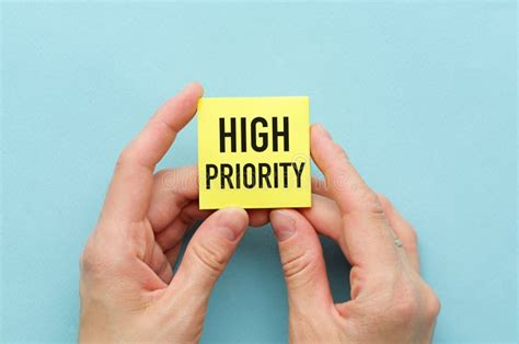 high priority text written  sticky  hands  blue background stock