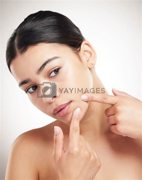 Royalty Free Image | Beautiful young woman popping a pimple standing