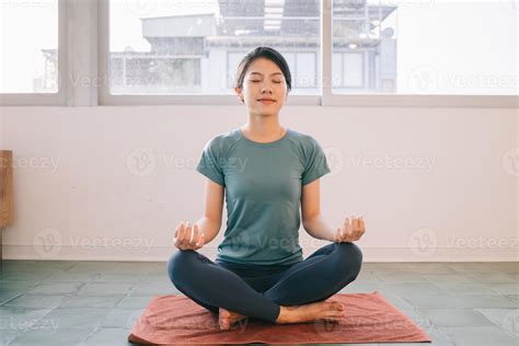 Young Asian woman doing yoga at home 4797686 Stock Photo at Vecteezy