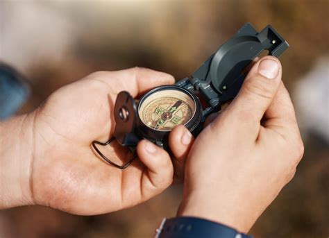 premium photo hands compass  travel  direction map  location