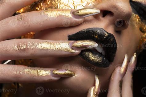 Beauty fashion model girl with golden make-up and body on black