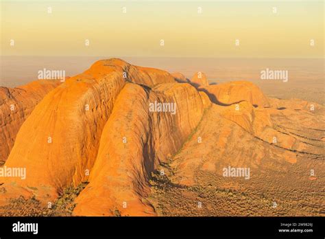 An aerial view of large sandstone formations at sunset. Uluru-Kata ...