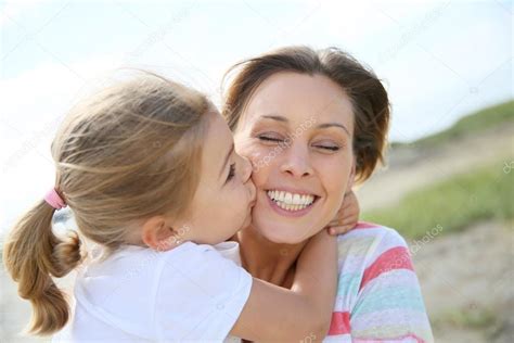 girl kissing  mom stock photo  goodluz