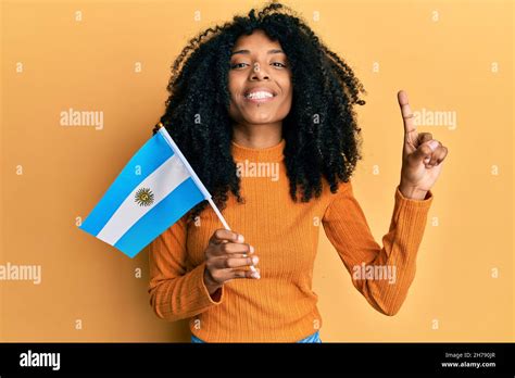 African american woman with afro hair holding argentina flag smiling ...