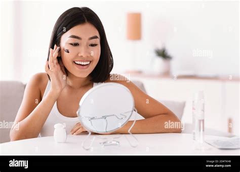 Portrait of asian woman cleaning her face with scrub Stock Photo - Alamy