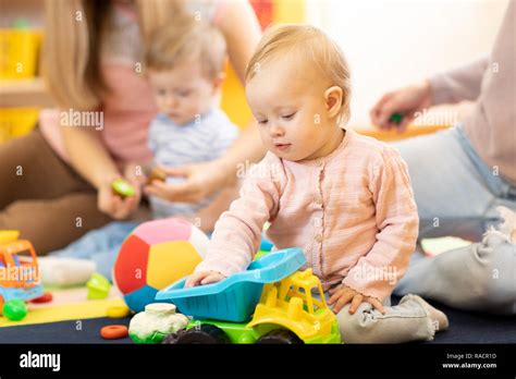 Group of babies with mothers playing toys at playgroup Stock Photo - Alamy