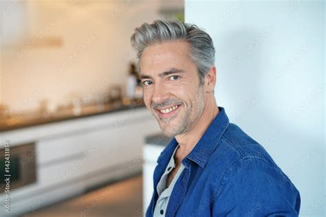 Smiling handsome 45-year-old man standing by home kitchen Stock Photo ...