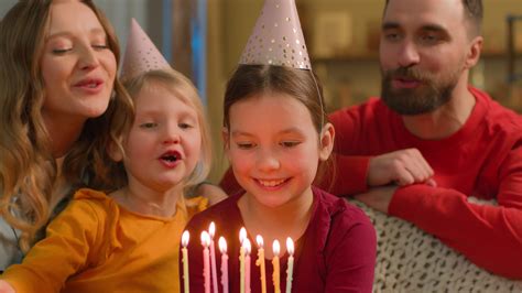 Caucasian family sing happy birthday little girl child daughter blow
