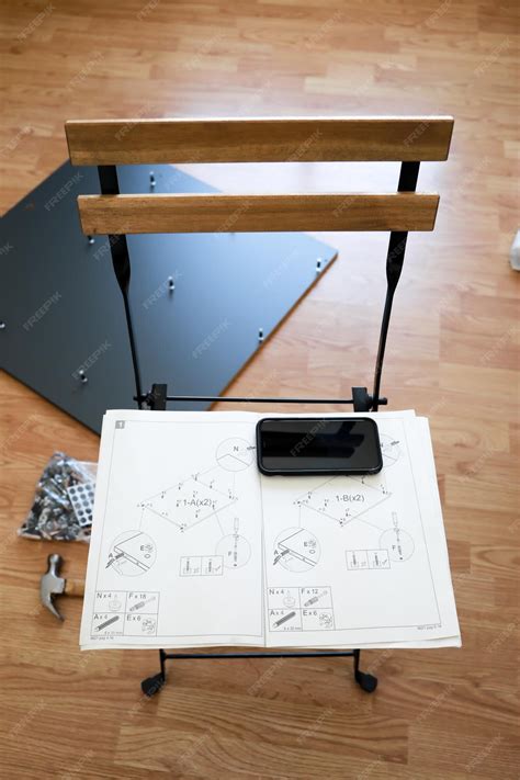 Um martelo e um móbile com instruções de como montar um roteiro cinza