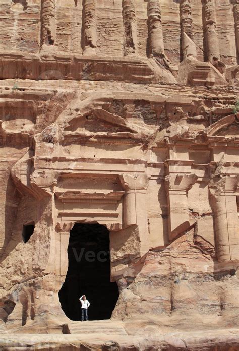 Young man wearing a hat in a monumental building carved out of rock in