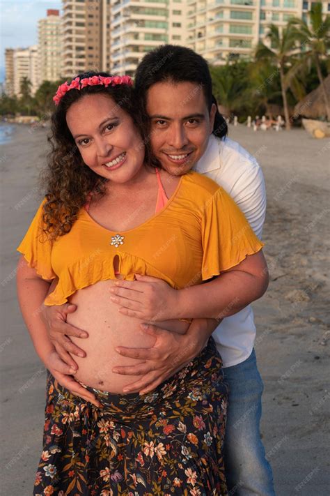 Premium Photo | Latin husband hugging his pregnant wife at the beach