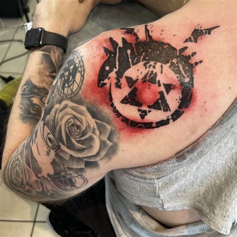 a man with a tattoo on his arm and shoulder has a rose in the center