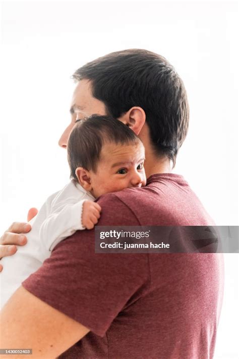 father carrying  newborn baby   shoulder  white