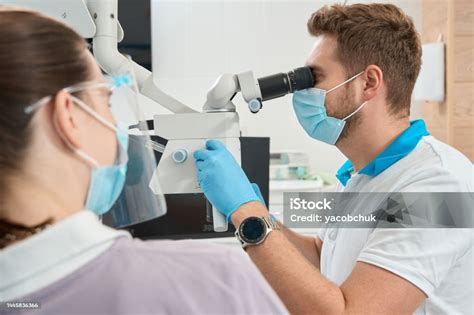 qualified dentist adjusting modern optical instrument  work stock