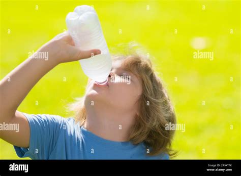 Niño pequeño bebiendo una botella fresca de agua. El niño sediento que ...