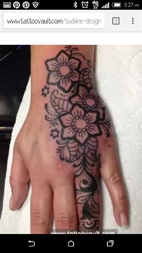 a woman's hand with a flower tattoo on it