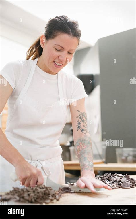 Frau trägt eine weiße Schürze an einem Schalter der Arbeit in einer ...