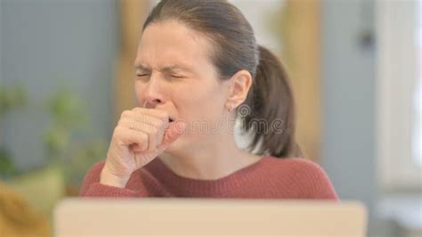 close   beautiful woman coughing  working  laptop stock