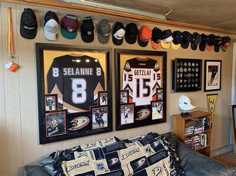 man cave wall  framed jerseys  hats  signed pucks spanning