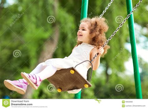 Child Swinging on a Swing at Playground in the Park. Stock Photo ...