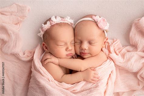 Tiny newborn twin girls. A newborn twin sleeps next to his sister ...