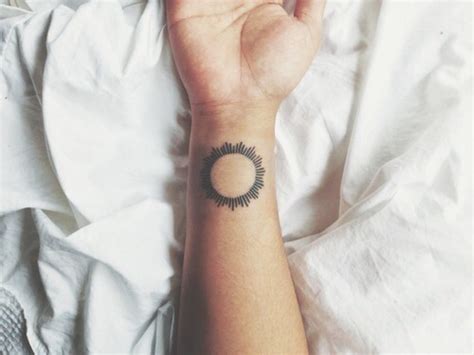 Black sun tattoo on the right wrist - Tattoogrid.net